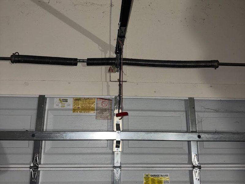 Torsion spring assembly across a closed sectional door